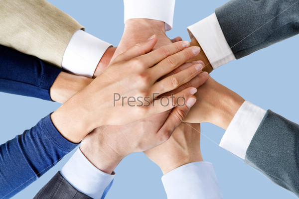 Photo of business people’s hands on top of each other