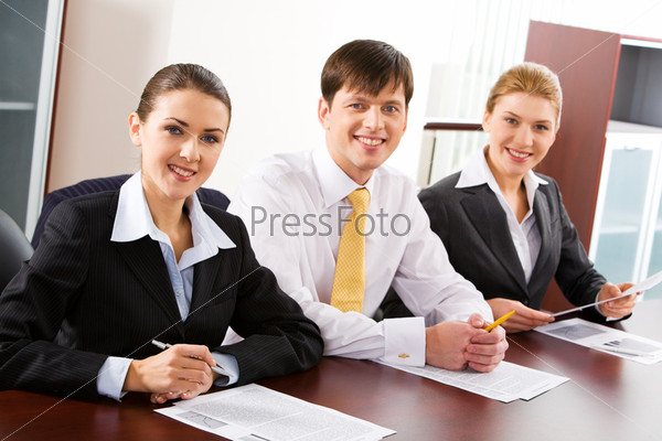 Image of three business people sitting at the table in a line , stock photo
