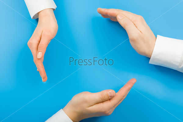 Conceptual circle made from human hands on a blue background