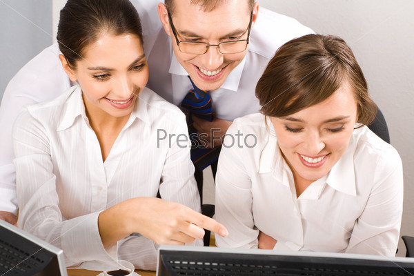 Portrait of three white collar workers looking at the monitor of computer