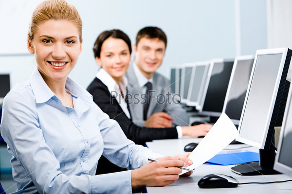 Three mature students sitting in a row in the computer classroom with smiles