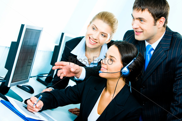 Photo of group of confident businesspeople looking at the monitor of computer with smiles in the computer classroom