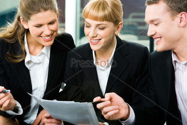 Portrait of three white collar workers looking at the document