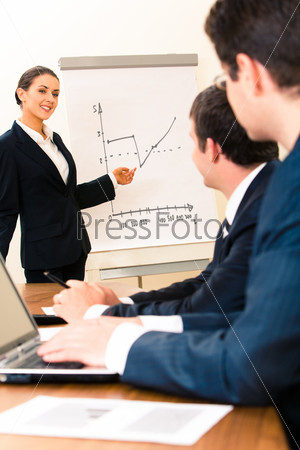 Photo of confident speaker giving a presentation at business meeting