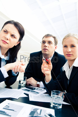 Portrait of confident business team looking at something during meeting in the workshop