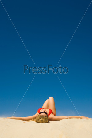 Creative image of sunbathing woman on the background of sky
