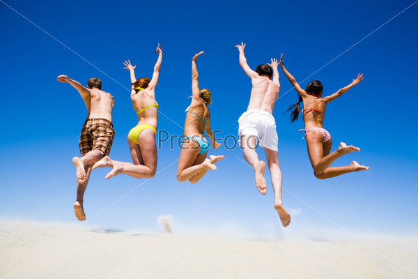 Portrait of jumping young people a backs on the beach