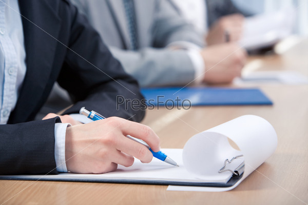 Human hand with pen over paper ready to write something