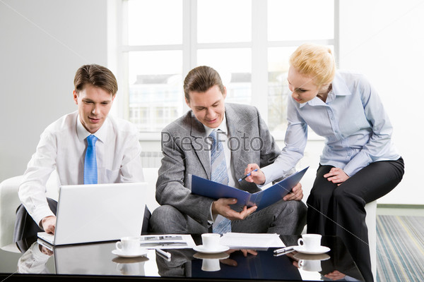Photo of three employees planning their work together in office
