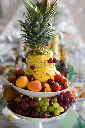 Mixture of different fruits and berries on plates as part of wedding table