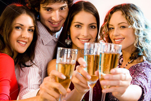 Portrait of four people holding glasses of  champagne,