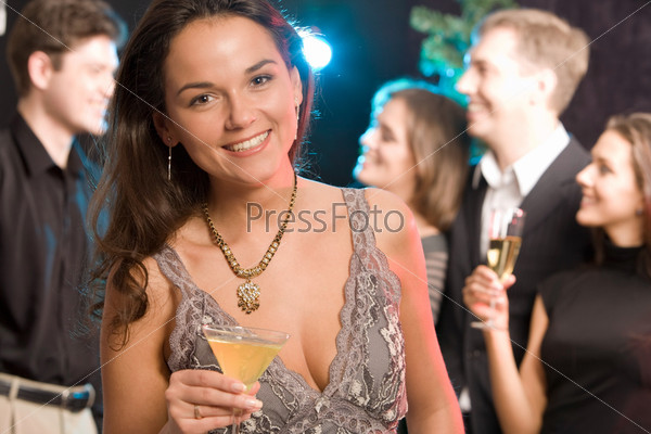 Portrait of charming woman holding her cocktail on the background of people