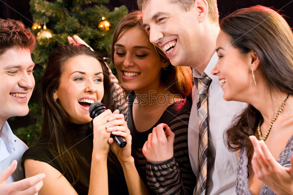 Portrait of several people singing a song together at a karaoke party