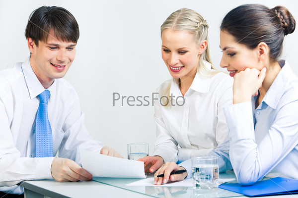 Portrait of three business people sitting at the table and planning their work