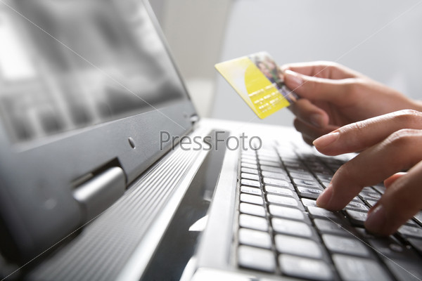 Image of hands holding credit card and pressing a keys of  keyboard