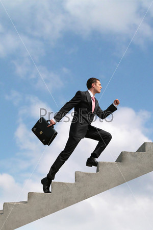 Image of confident businessman with briefcase walking upstairs