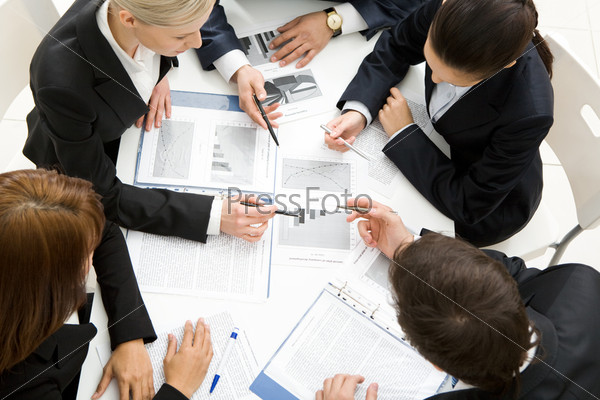 Above view of successful workteam discussing new plan at meeting