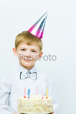 Photo of cute child holding the cake with candles