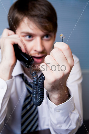 Photo of troubled man looking at disconnected telephone hub in his hand