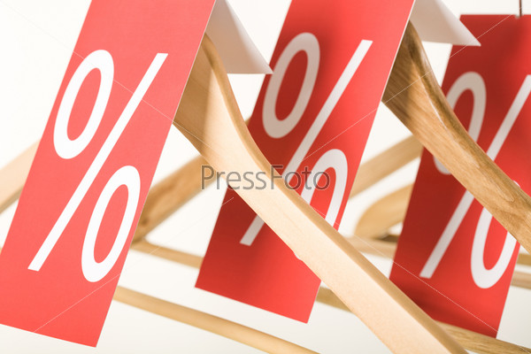 Close-up of red price lists on wooden hangers during xmas sale