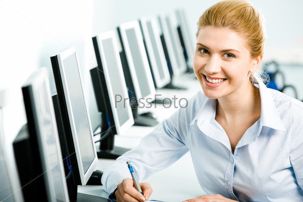 Portrait of student or teacher sitting at the computer table in front of monitor