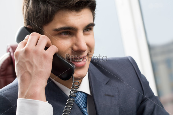 Photo of smart businessman calling somebody and smiling during communication, stock photo
