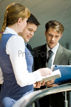 Photo of confident business lady explaining something to co-workers at meeting