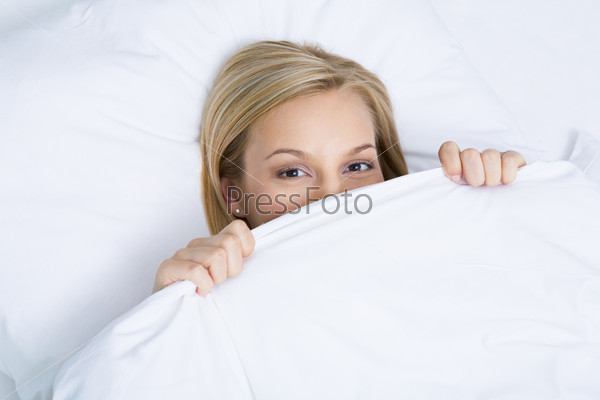 Photo of pretty woman peeping out of white linen