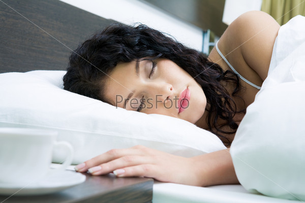 Photo of pretty woman sleeping peacefully in white linens
