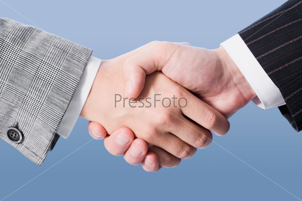 Close-up of shaking hands making an agreement on the blue background