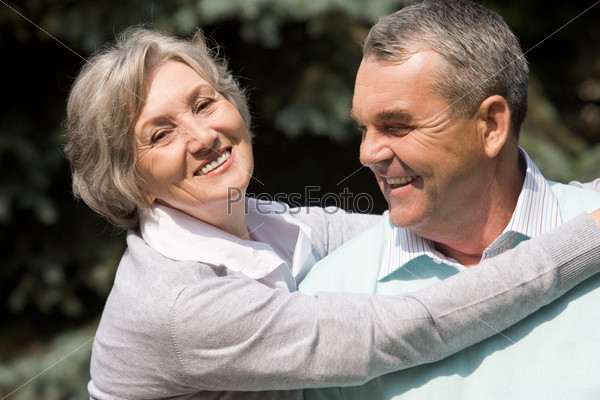 Portrait of senior female embracing her husband while he laughing