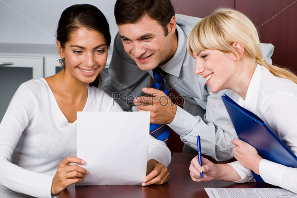 Manager provides an explanation to his colleagues pointing at a document