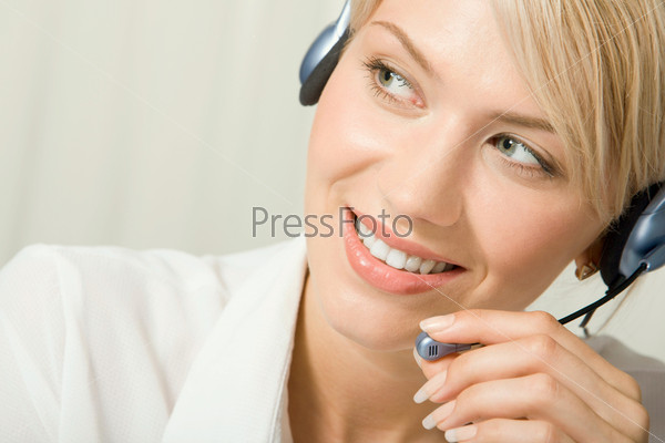 Portrait of friendly smiling telephone operator holding headset