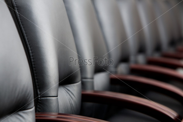 Row of leather black chairs in a boardroom