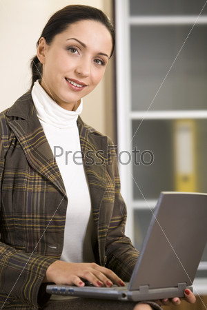 Beautiful Hispanic business lady is working on her notebook