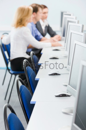 Students are sitting at tables in the computer room, stock photo