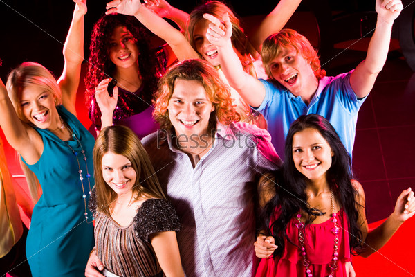 Joyful teens having fun in night club while dancing