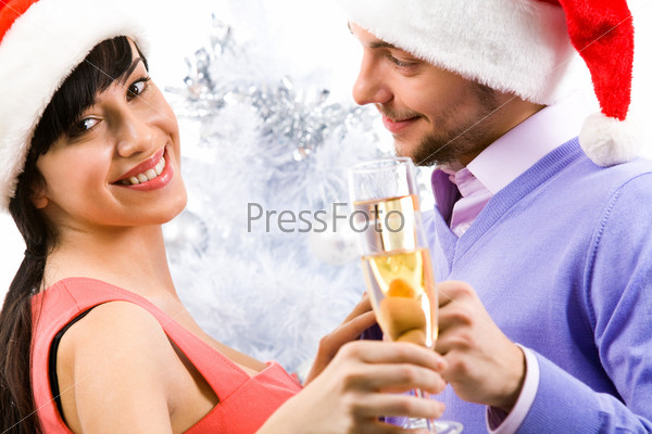Portrait of happy female with champagne flute with her husband near by