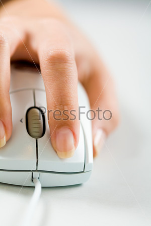 Close-up of female hand on white mouse during computer work