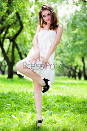 Smile girl dance in white dress in park