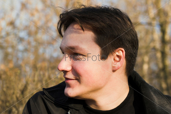 Brunet boy profile,thoughtful smiling portrait in the forest
