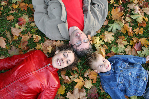 family lies on maple leaves