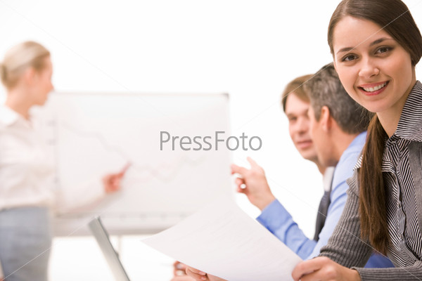 Image of confident lady looking at camera on background of working business team