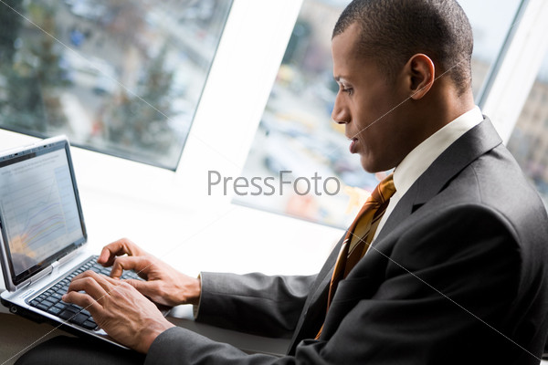 Photo of handsome employee working in office with laptop in front
