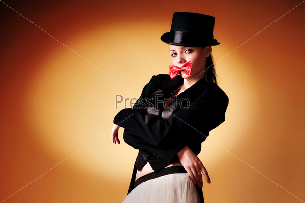 beautiful young girl in a tuxedo on an orange background