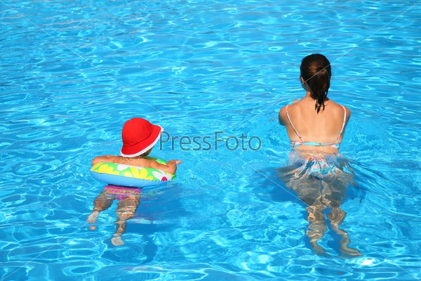 Mum and the daughter float in pool