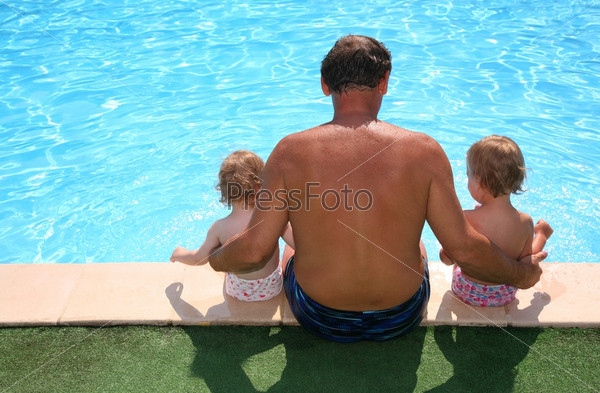 Grandfather with granddaughters seats aboard of pool
