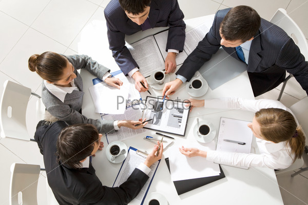 Above view of business team sitting around table and discussing working plan