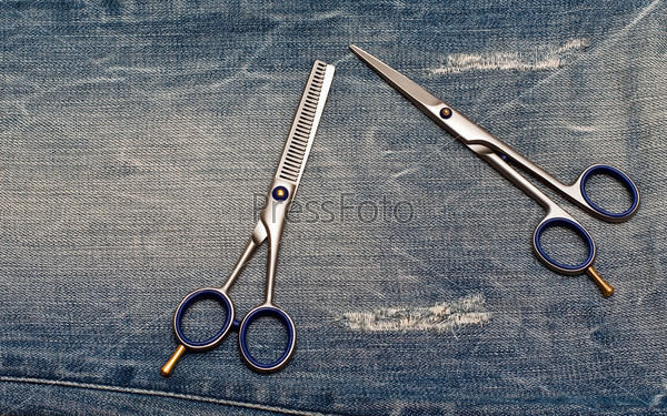 Hairdressing scissors on the blue jeans