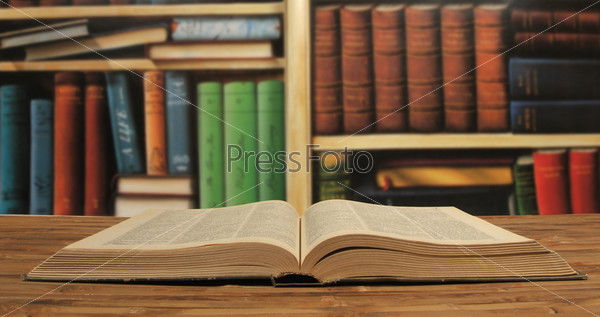 opened textbook on a bookshelves background